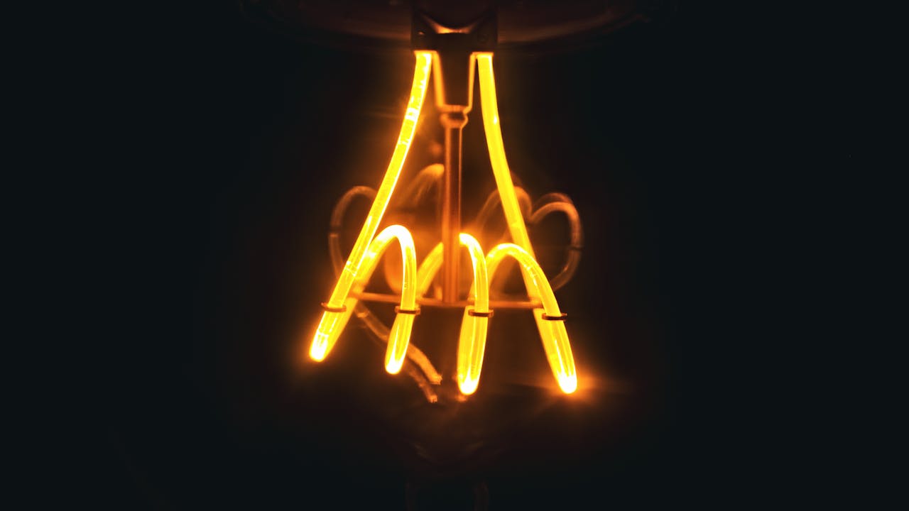 Close-up of a glowing spiral filament in a light bulb, creating a warm and vibrant effect.